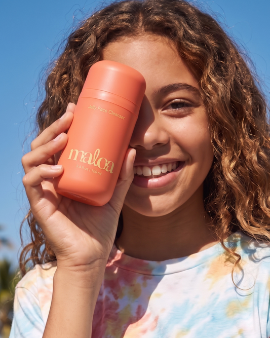 tween holding jelly face cleanser up to face
