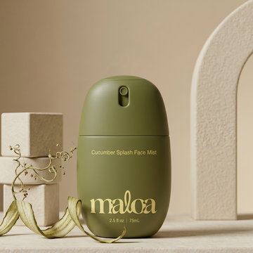 Green face mist bottle labeled 'maloa' on a neutral background